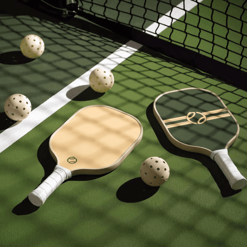 Pickleball paddles and balls arranged on a court